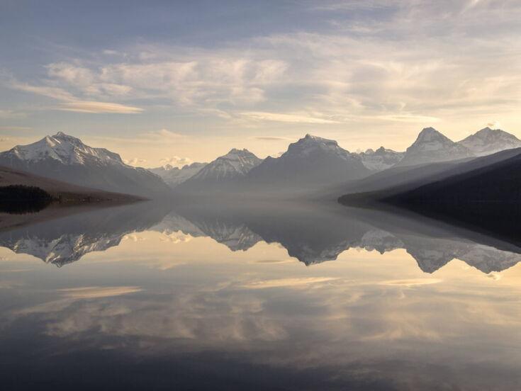 Gebirge spiegelt sich in glatter Wasseroberfläche