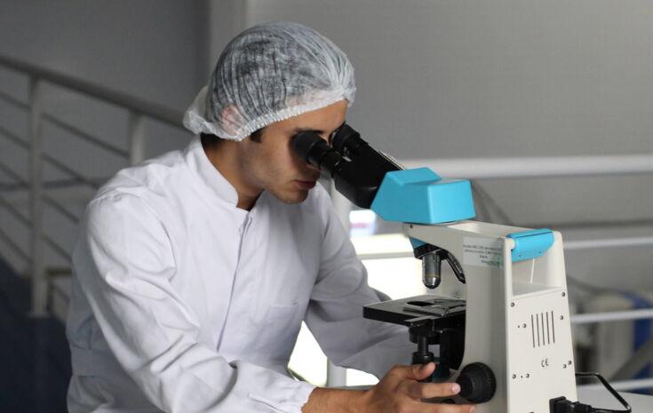 Chemiker schaut durch ein Mikroskop
