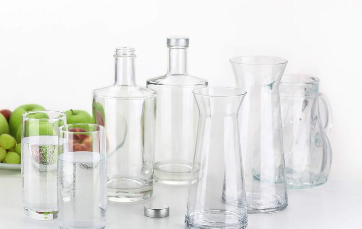 Mehrere Glasflaschen und Karaffen stehen auf einem Tisch.