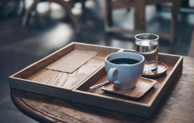 Kaffee und Wasser auf einem Tablett serviert
