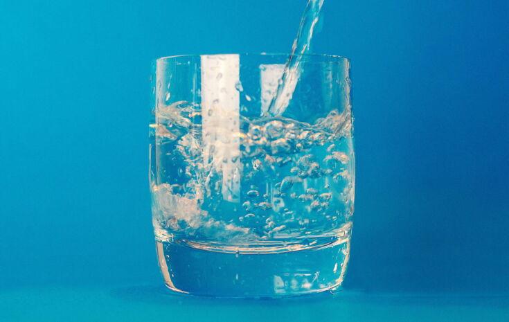 Wasserglas auf blauem Hintergrund
