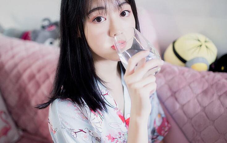 Asiatin trinkt aus einem Glas