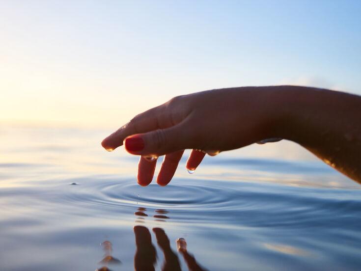 Hand berührt das Wasser