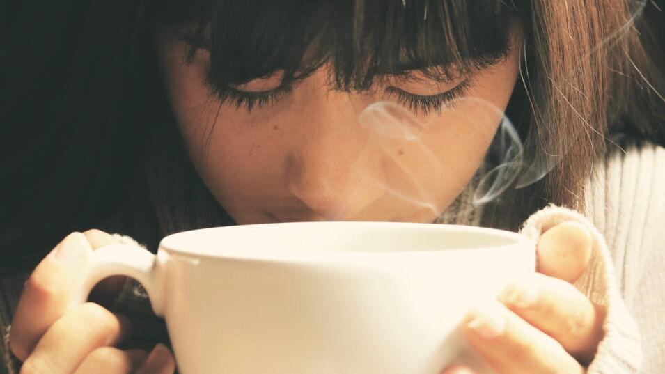 Eine Frau trinkt Kaffee aus einer Tasse