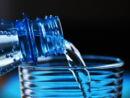 Wasser aus Plastikflasche in Glas eingießen