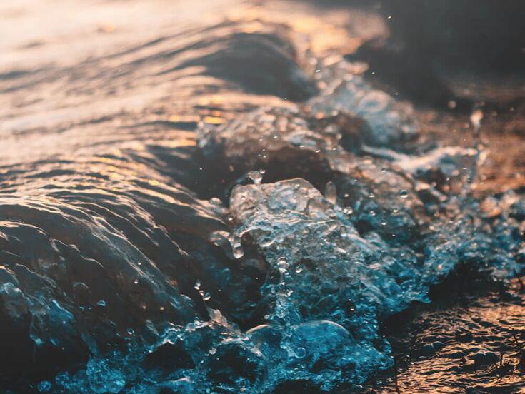 Wasser fließt an Strand