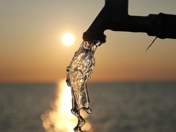 Wasser fließt aus einem Wasserhahn im Sonnenuntergang