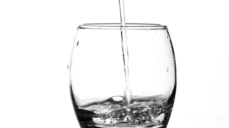 Wasser wird in ein Wasserglas gefüllt